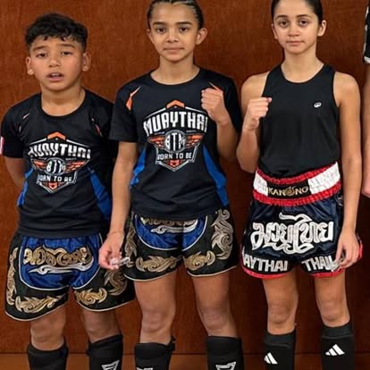 Trois jeunes en tenue de Muay Thaï