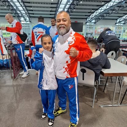 Jeune boxeuse et coach en tenue officielle lors d'un tournoi